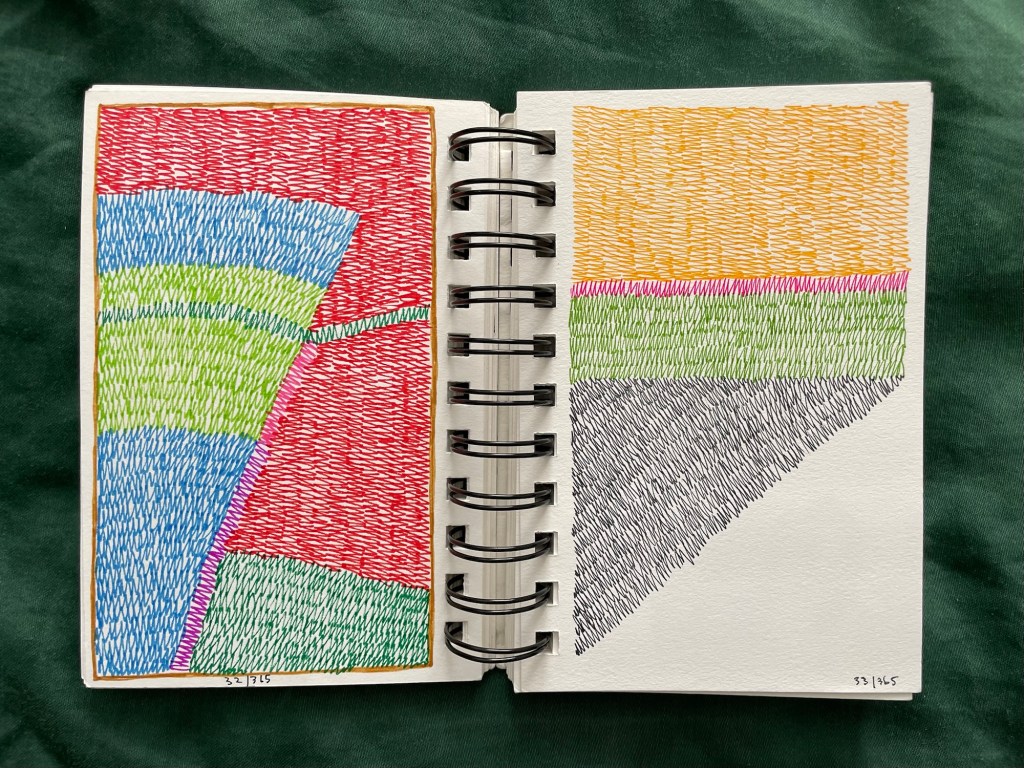 Wire bound sketchbook with line drawing on the open pages, laying on top of green fabric