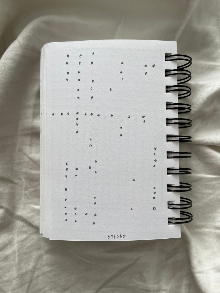 Wire bound sketchbook with line drawing on the open page, laying on top of white fabric